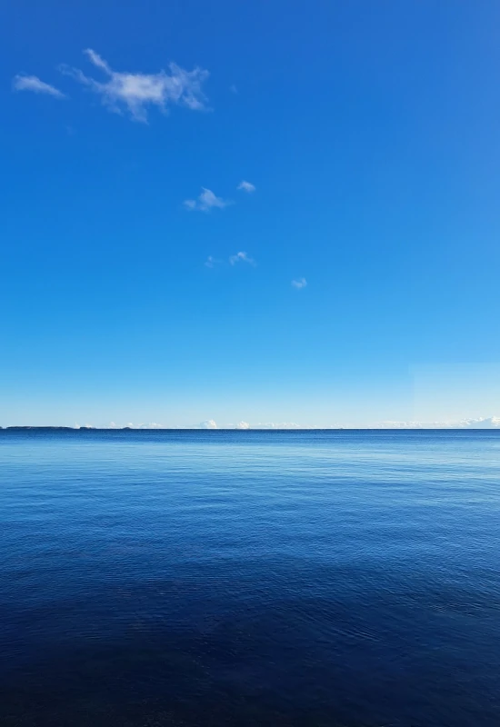 Ääretön ja tyyni, sininen merimaisema. Levollinen kuva symboloi yrittäjän energiataloutta, uupumuksen taklaamista ja arjen rauhaa.